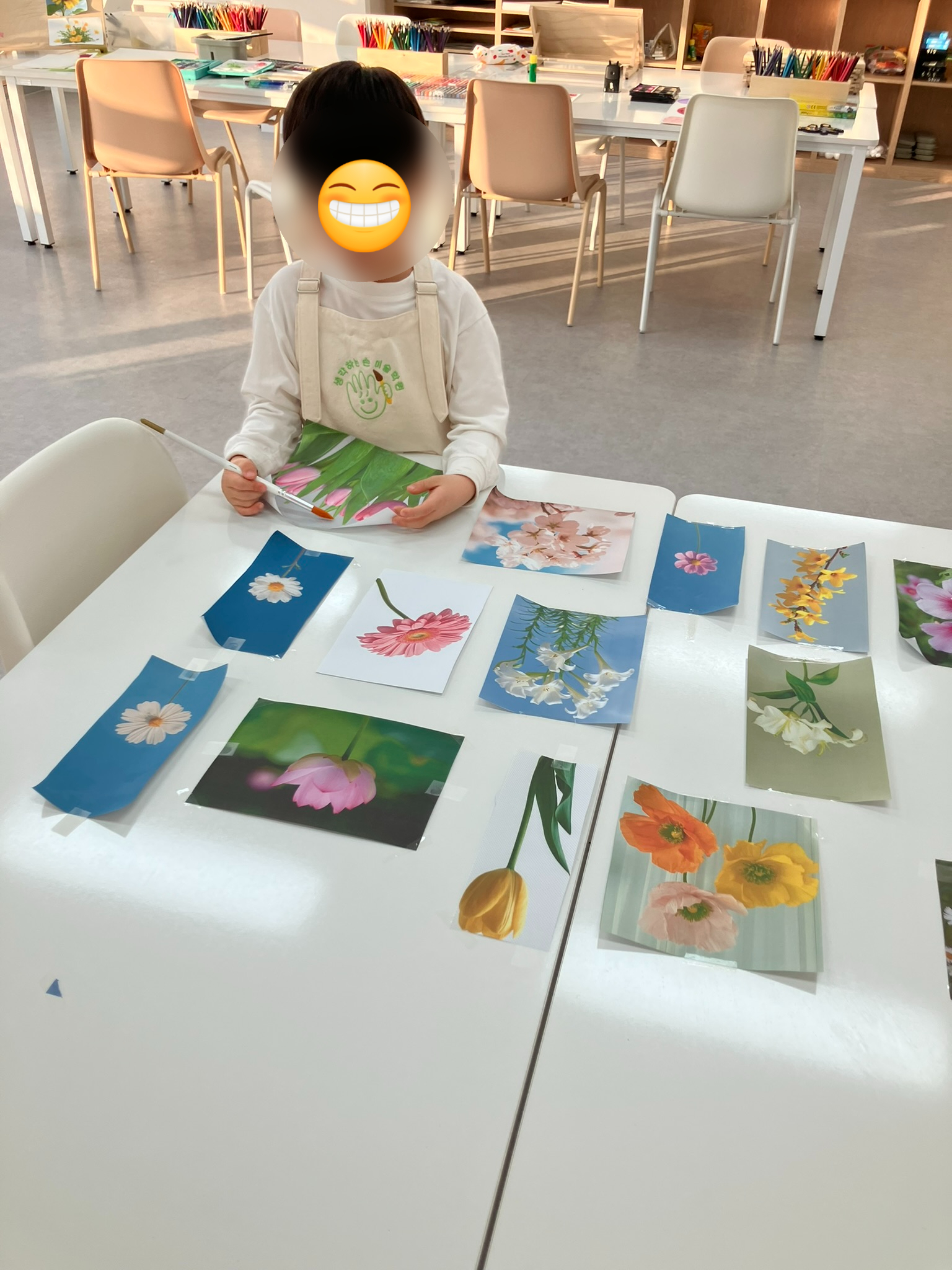 꽃 사진을 옆에 두고 작업하는 학생